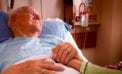 Old man lying in hospital bed holding daugher Half of Canadians don’t even know what palliative care is